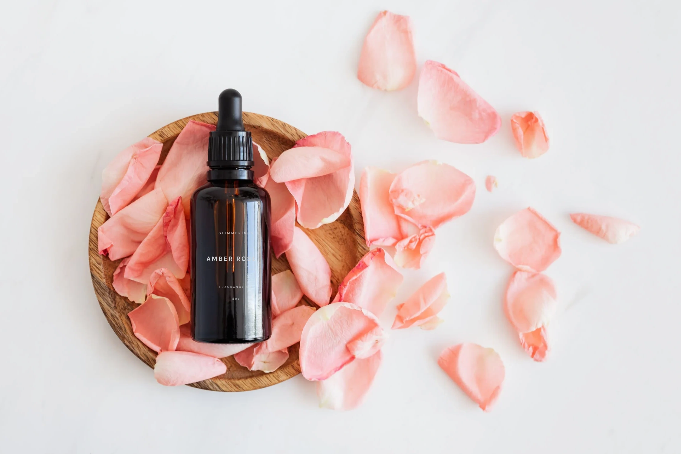 Amber Rose fragrance bottle with rose petals